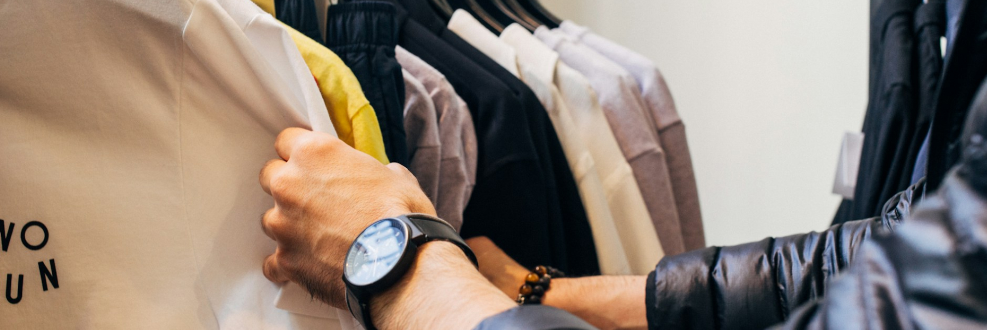 Shoppers browsing clothing rack with security precautions